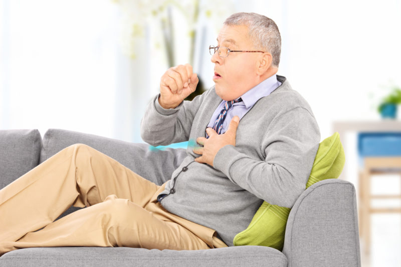 man coughing on couch